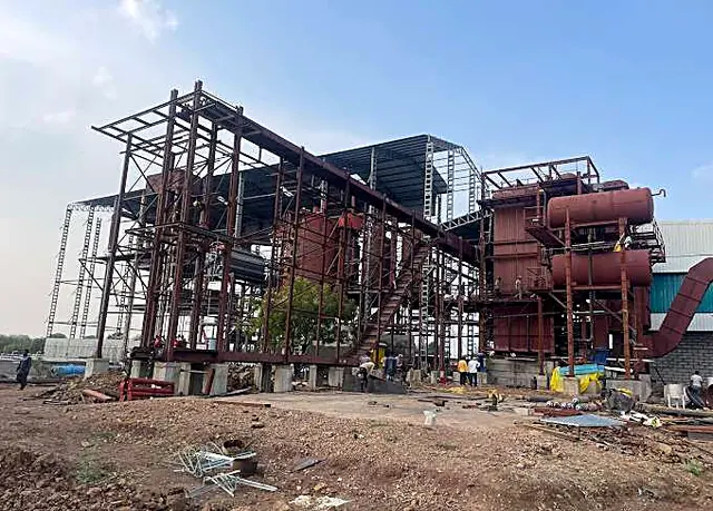 Sugar plant under construction, with steel structures and a boiler