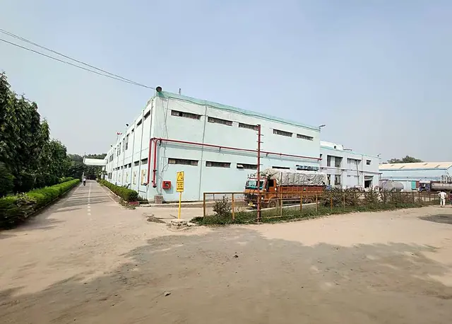 Paint factory buildings along a wide yard