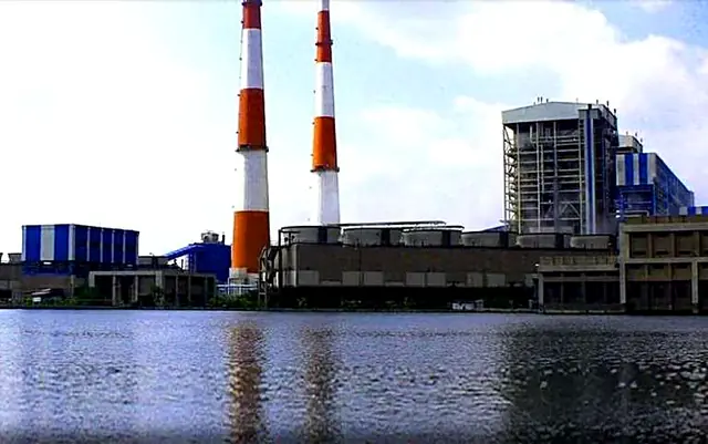 Thermal power station with twin chimneys beside a lake